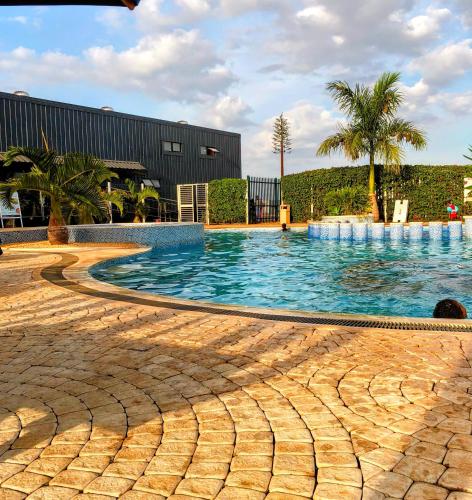 a large swimming pool with palm trees and a building at The House Beautiful, Tatu City in Tatu City