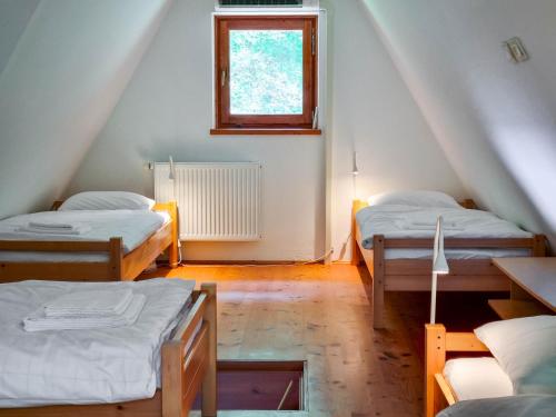 a attic room with three beds and a window at Jakob Cabin in Bovec