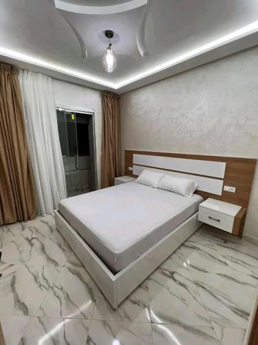 een slaapkamer met een bed en een marmeren vloer bij مارتيل حي احريق in Martil