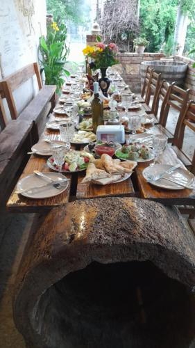 einen langen Holztisch mit Teller Essen drauf in der Unterkunft gogia in Zqaltubo