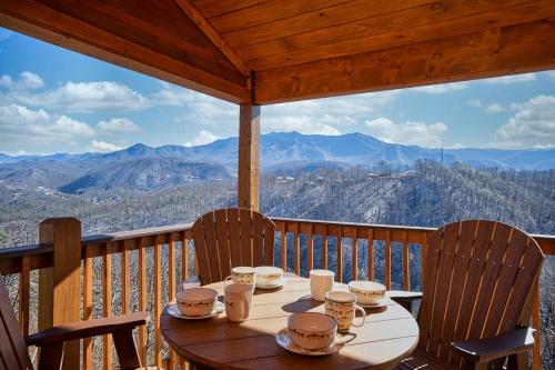 a table on a balcony with a view of mountains at The Bear and Trout by Stony Brook Cabins in Gatlinburg