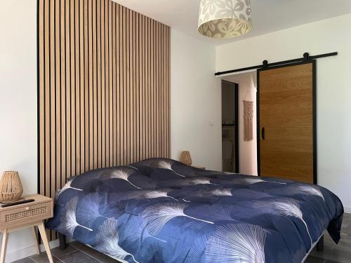 - une chambre avec une couette bleue sur un lit dans l'établissement Le cosy du roi, à Fontenay-le-Fleury