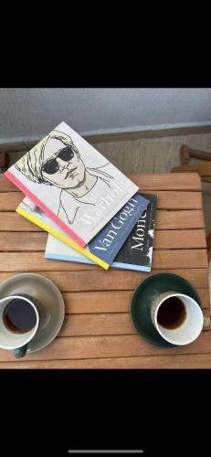 a wooden table with two books and a bowl of coffee at Hanole Guest House in Ayvalık