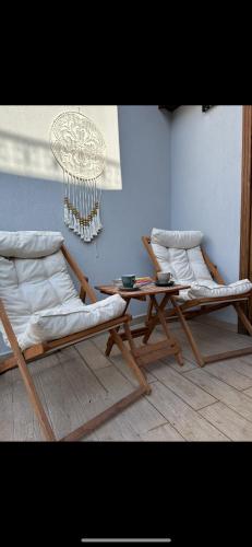 two lounge chairs and a table in a room at Hanole Guest House in Ayvalık