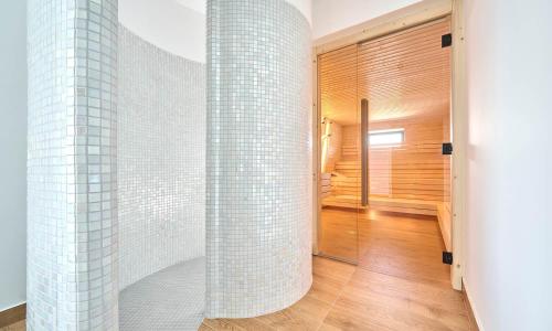a bathroom with white tiled walls and a walk in shower at Aminess Style Glamping Villas & Holiday Homes Atea in Njivice