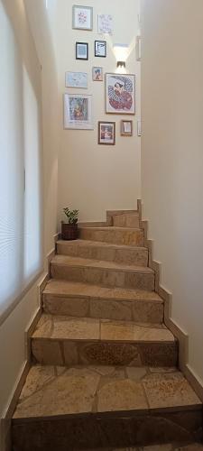 a stairway with a potted plant and pictures on the wall at Country Nest in Messini