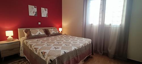 a red bedroom with a bed and a window at Country Nest in Messini