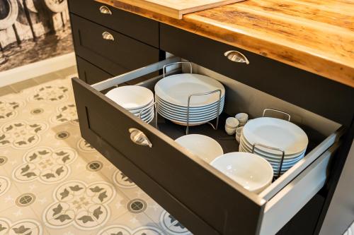 a drawer with plates and dishes in a kitchen at Ferienwohnung Hafen in Schleswig
