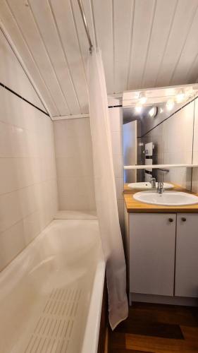 une salle de bain blanche avec une baignoire et un lavabo dans l'établissement Résidence Hameau - Chalets pour 8 Personnes 59, à Flaine