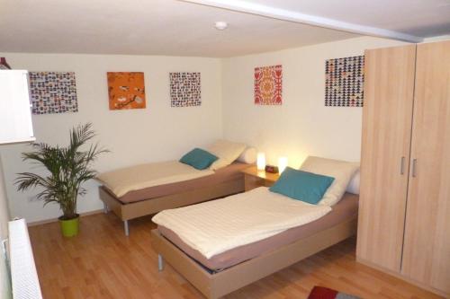 um quarto com duas camas e um vaso de plantas em Haus des Handwerkers em Koblenz