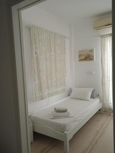 a white bed in a room with a window at Four season in Ios Chora