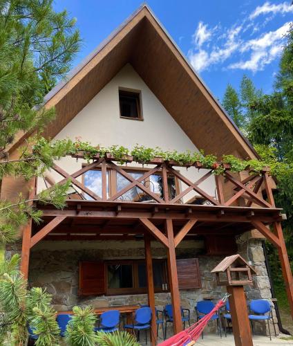 a log cabin with a wooden roof and blue chairs at Chata Dolce Donovaly in Donovaly