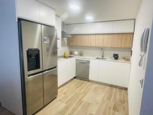 コルドバにあるLa Medina de las Floresの白いキャビネットとステンレス製の冷蔵庫を備えたキッチン