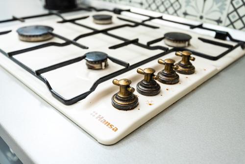 a white stove top with bronze knobs on it at iVAVev IS US ByTheSea EforieSud in Eforie Sud