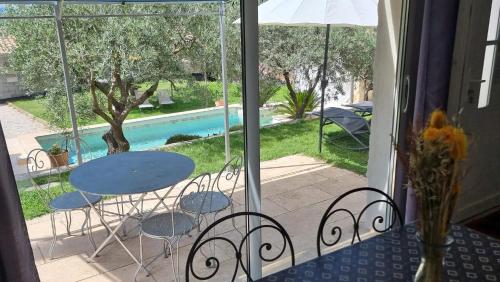 d'un balcon avec une table, des chaises et une piscine. dans l'établissement Le Mas de la Tortue (Plain Pied), à Caromb