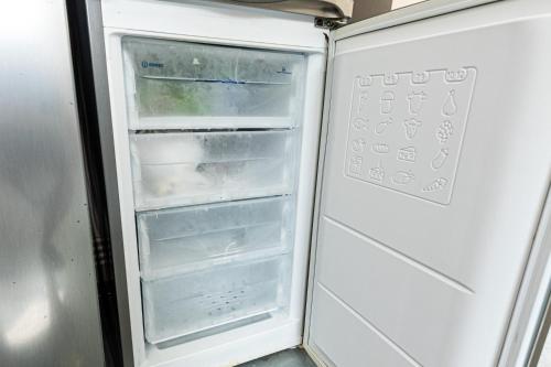 an empty refrigerator with its door open in a kitchen at iVAVev IS US ByTheSea EforieSud in Eforie Sud
