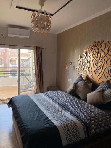 a bedroom with a large bed with a tree headboard at LA BELLA VIDA in Saïdia