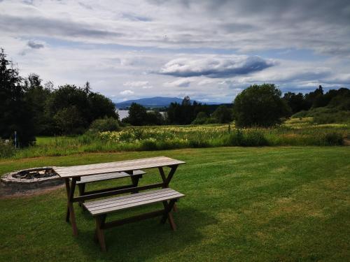 a wooden picnic table and bench in a field at Penzion Kovářov in Frymburk