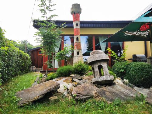 a garden in front of a house with a lighthouse at Penzion Kovářov in Frymburk