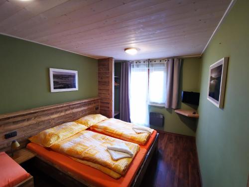 a bedroom with a bed in a room with green walls at Penzion Kovářov in Frymburk