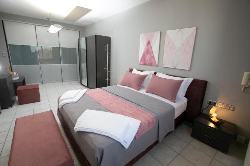 a bedroom with a large bed with pink pillows at CASTLE VIEW luxury apartment with Free Private Parking in Kavala