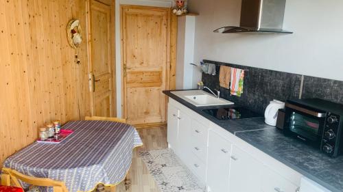 a small kitchen with a table and a sink at Belle Vue in Pers-Jussy