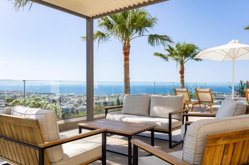 een terras met stoelen, tafels en palmbomen bij Karmilos Hill Villa in Chania