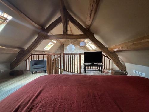 - une chambre mansardée avec un lit et une télévision dans l'établissement Mini duplex la Révière, à Saintines