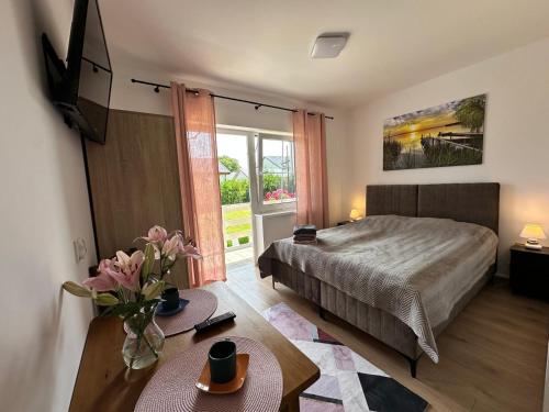 a bedroom with a bed and a large window at Ośrodek Polny Kamyk in Wicie