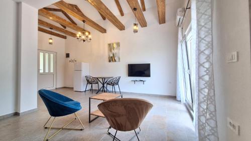 a living room with a table and chairs and a tv at Seaside Village in Kamenari