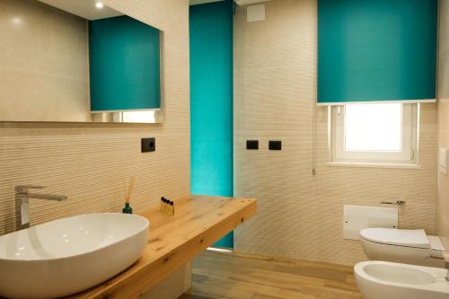 a bathroom with a white sink and a toilet at Mazzini House B&B in Sassari