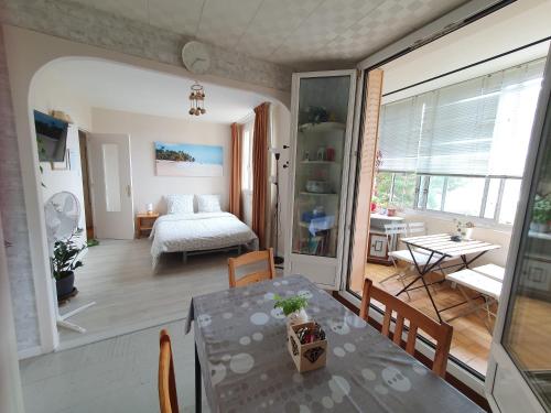 un salon avec une table et une chambre dans l'établissement Médipôle T2 avec un garage gratuit sur place, 16min à centre ville Lyon en métro A, à Villeurbanne