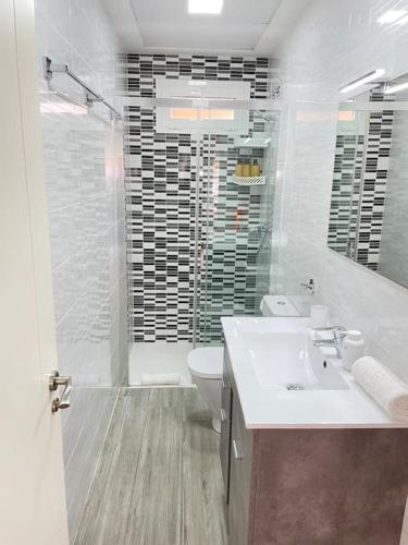 a bathroom with a sink and a toilet and a shower at Seahorse apartment El Perelló in El Perelló