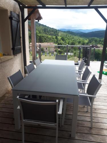 une table et des chaises blanches sur une terrasse avec vue dans l'établissement Maison Des Levriers met zwemvijver en airco in Katharenland, à Luc-sur-Aude