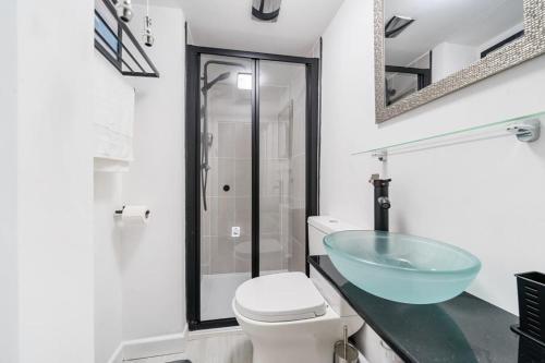 ein Badezimmer mit einem Glaswaschbecken und einem WC in der Unterkunft Fowey, Cute Cottage in Fowey