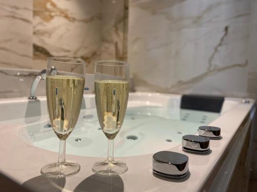 trois verres de champagne assis sur une baignoire dans l'établissement Le cocon du désir - Balnéo et haut de gamme, à Saint-Nazaire