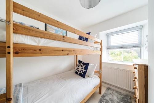 ein Schlafzimmer mit zwei Etagenbetten und einem Fenster in der Unterkunft Fowey, Cute Cottage in Fowey
