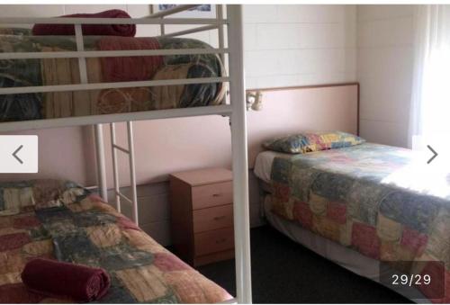 two bunk beds in a small room with two beds at Black swan motor inn in Lakes Entrance