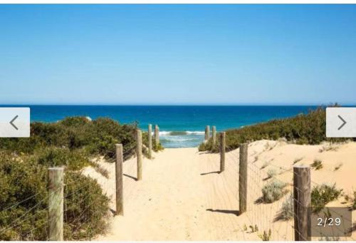 a sandy path to the beach with the ocean at Black swan motor inn in Lakes Entrance