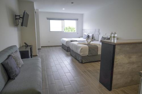 a hotel room with two beds and a couch at SR Hotel in Guadalajara