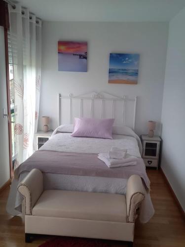 a bedroom with a white bed with a pink pillow at Piso DJC in O Pedrouzo