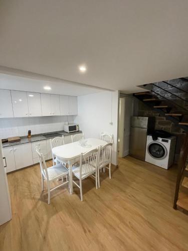 a kitchen with a white table and chairs in a room at Casa duples junto playa Cubelas in San Ciprián