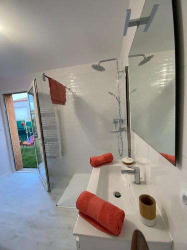 a white bathroom with a sink and a mirror at Chambre d'hôtes chez Marie Pierre in Nissan-lez-Enserune