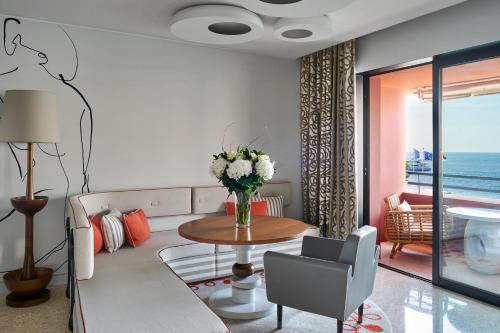 a living room with a couch and a table with flowers at Monte-Carlo Beach in Roquebrune-Cap-Martin