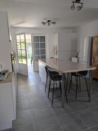 - une cuisine avec une grande table et des chaises dans l'établissement Maison de famille Meschers sur Gironde à 14 mn à pieds de la plage, à Meschers-sur-Gironde
