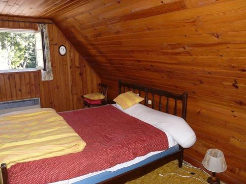 ein Schlafzimmer mit einem Bett in einer Blockhütte in der Unterkunft Chalet in Bolquere
