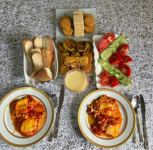 a table with plates of food and a box of bread at Mark in Yeghegnadzor