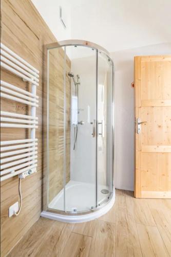 - une douche en verre dans une chambre dotée d'un mur en bois dans l'établissement Villa Blanche - Suite en Provence, à Draguignan