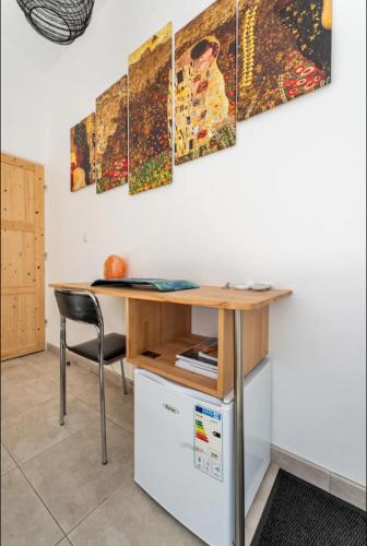 - un bureau avec une chaise à côté d'un mur orné de peintures dans l'établissement Villa Blanche - Suite en Provence, à Draguignan