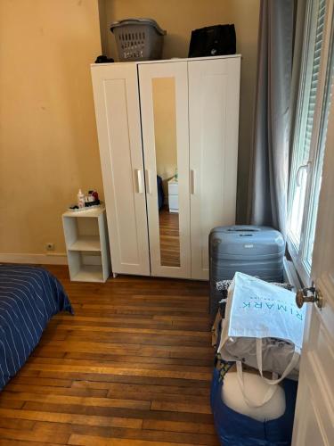une chambre avec un lit, des bagages et un miroir dans l'établissement Monteleone Appart, à Paris